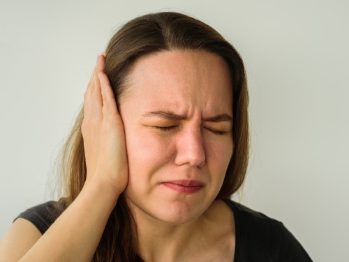 Junge Frau mit Ohrenschmerzen